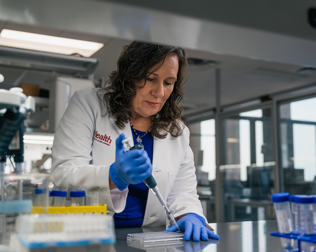 Image of an OU Health Researcher in the lab using instruments to condcut research.